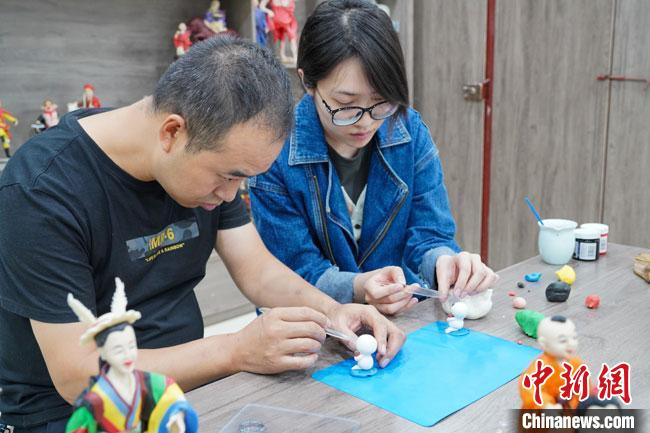 <a target='_blank'  data-cke-saved- >中新社</a>記者(右)現(xiàn)場體驗面塑制作過程。　陳爭強 攝