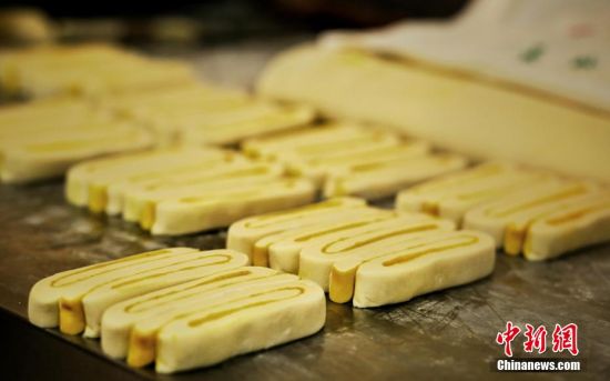 圖為面劑被涂上胡麻油，切成條狀用作月餅的花型制作。張文 攝