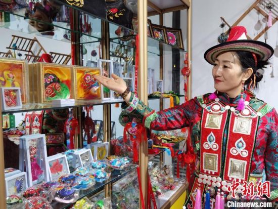 圖為身著民族服飾的隴原巧手展示手工藝品。(資料圖) 徐雪 攝