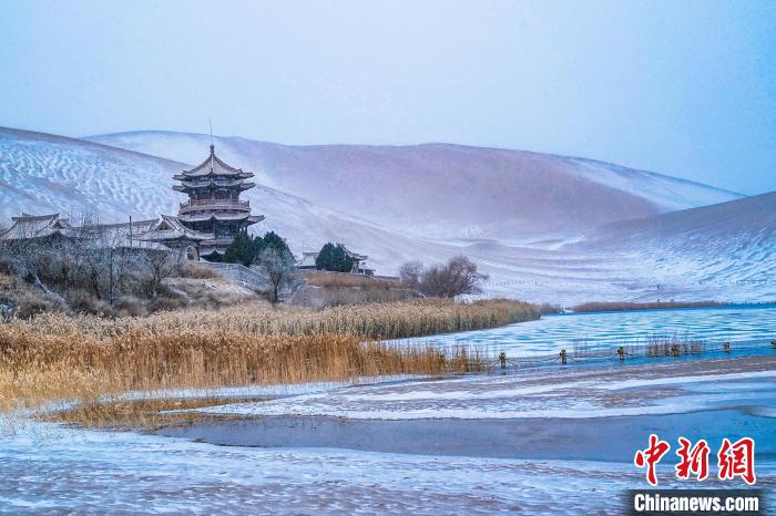 2021年11月28日，雪落鳴沙山月牙泉景區(qū)。　王斌銀 攝