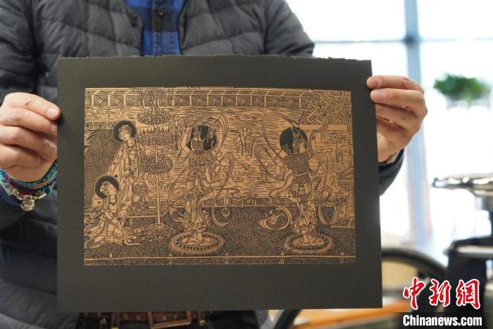 圖為手工書藝人展示敦煌雕版壁畫印刷品?！【琶赖┰?　攝