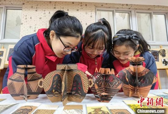 圖為學(xué)生用紙創(chuàng)作的立體彩陶?！⒂裉?攝