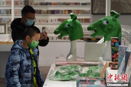 圖為“神馬來了”銅奔馬頭套吸引參觀者駐足?！【琶赖┰?攝