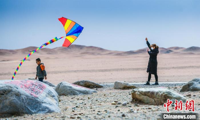 圖為市民正在陽關(guān)景區(qū)放風(fēng)箏。　王斌銀 攝