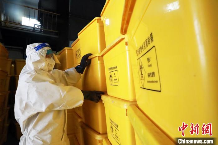圖為工作人員搬運(yùn)醫(yī)療廢物專用周轉(zhuǎn)箱?！∥航ㄜ?攝