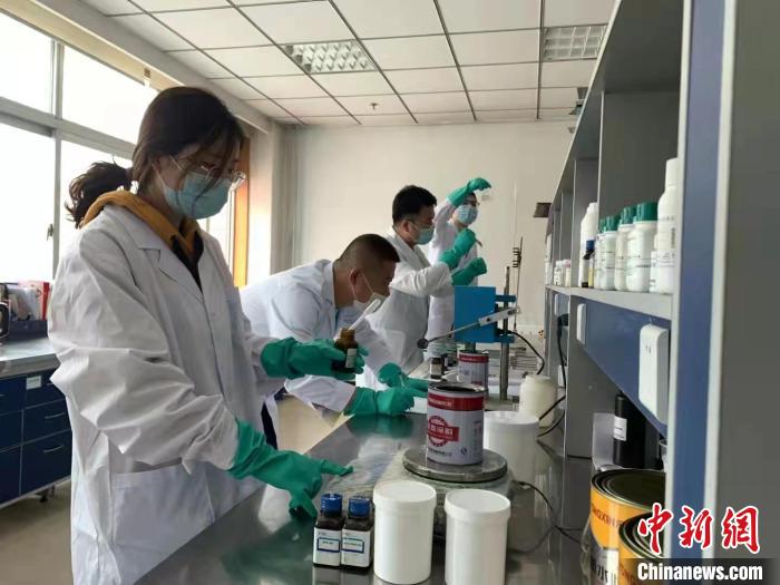 圖為肖菲(前一)帶領團隊研發(fā)水性涂料。(資料圖) 受訪者供圖