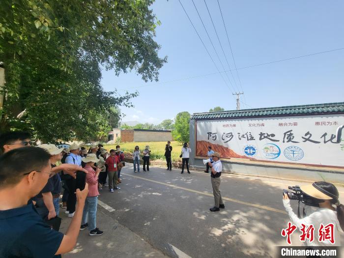 圖為中國(guó)地質(zhì)大學(xué)(北京)教授張緒教介紹村落情況?！『衍?攝