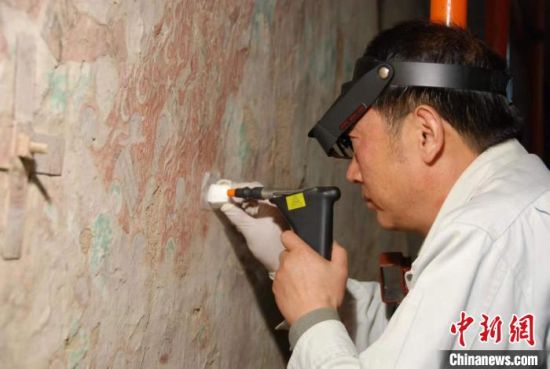 敦煌研究院研究員樊再軒進(jìn)行壁畫(huà)修復(fù)。(資料圖)張?jiān)莆?攝