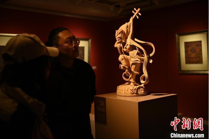 圖為季茂杰向參觀者介紹自己創(chuàng)作敦煌木雕的過程。李亞龍 攝</p>
<p>