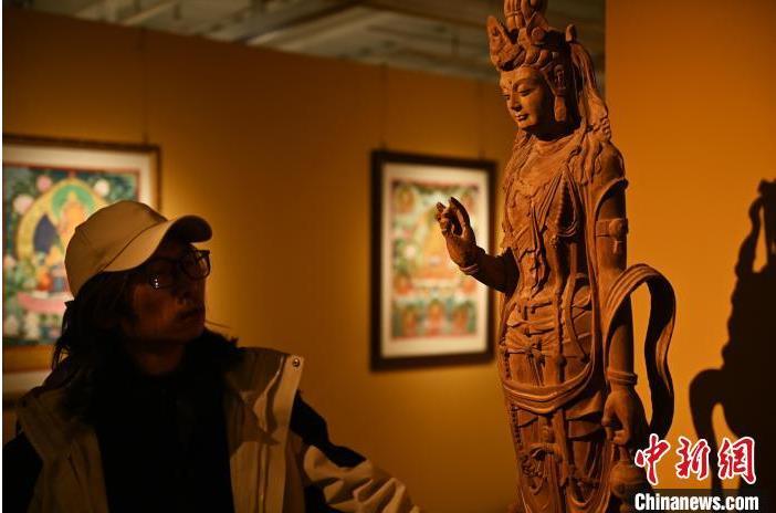 圖為季茂杰觀察自己創(chuàng)作的敦煌木雕。李亞龍 攝</p>
<p>