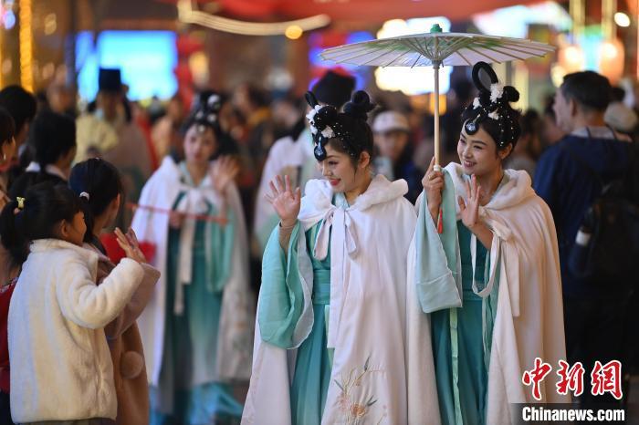 圖為街區(qū)人員著傳統(tǒng)服飾與游人互動(dòng)。李亞龍 攝</p><p>