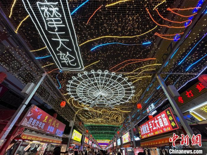 圖為明清街夜市燈光點(diǎn)亮具有武威文化元素的“摩天輪”彩燈?！〈魑牟?攝</p><p>