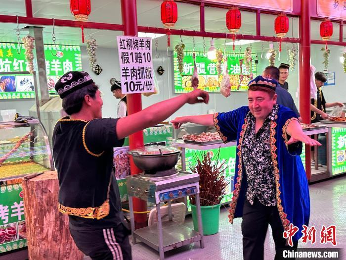 圖為餐飲經(jīng)營者在“西涼不夜城”跳起舞蹈引客?！〈魑牟?攝</p><p>