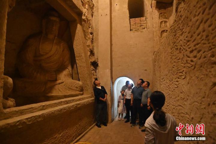 7月15日，游人參觀甘肅省平?jīng)鍪袥艽h百里石窟長廊中的王母宮石窟。百里石窟長廊位于涇川縣境內(nèi)，由512個石窟、5眼窟中石井組成，現(xiàn)存王母宮石窟、鳳凰山石窟、南石窟寺、丈八寺石窟、羅漢洞石窟、太山寺石窟等規(guī)模較大的石窟群，還有數(shù)量眾多的小石窟群。王母宮石窟又名千佛洞，該窟設(shè)計宏大，造像生動，窟內(nèi)擁有造像數(shù)百尊，是較為珍貴的佛教文化歷史遺存。中新社記者 李亞龍 攝</p>
<p>
